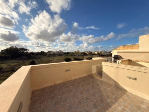 a balcony of a building with a cloudy sky at Panoramic View Penthouse With Dual Terraces in Xagħra