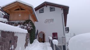 a building with snow on the side of it at Mas dal Vent in Valfloriana