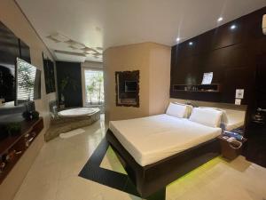 a bedroom with a bed and a bathroom with a toilet at Motel Sedución (Adults only) in Cascavel