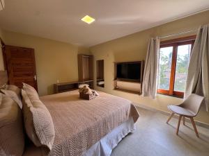 a bedroom with a teddy bear sitting on a bed at Zaya Beach Residence in Icaraí
