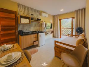 a kitchen and living room with a table and chairs at Zaya Beach Residence in Icaraí