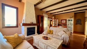 a living room with a couch and a fireplace at LA CASA ROJA Casa privada con piscina y vistas Zona Torrox in Torrox +36 photos