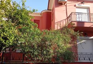 a building with a tree and a balcony at P & G Apartment in Pámfylla