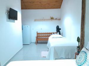 a room with a bed and a bench in it at Loft 01 encanto dos ipês in Paraty