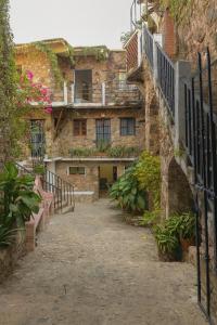 an alley in an old stone building with plants at Casa Centenario in Taxco de Alarcón