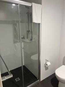 a shower stall in a bathroom with a toilet at Bondi Beach Studios Suite in Sydney
