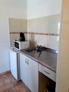 a small kitchen with a sink and a microwave at Rio Termal in Federación +78 photos