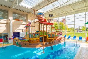 a large pool with a pirate ship in a building at Explorers Hotel Marne-la-Vallée in Magny-le-Hongre