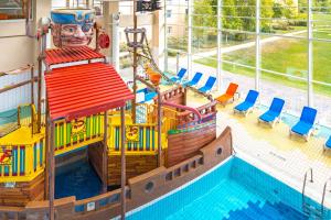 a pool in a hotel with a pirate ship themed pool at Explorers Hotel Marne-la-Vallée in Magny-le-Hongre +79 photos