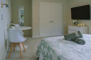 a bedroom with a bed and a table and a television at Welcome Bay Heights in Tauranga
