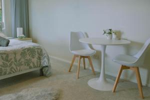 a bedroom with a table and two chairs and a bed at Welcome Bay Heights in Tauranga