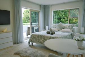 a bedroom with a bed and a table and a window at Welcome Bay Heights in Tauranga