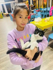 a young girl holding a black and white cat at Follow Me designed B&B in Dongshan