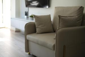 a couch with two pillows sitting in a living room at Orikum Getaway in Orikum