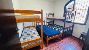 a room with two bunk beds and a window at Casa espaçosa 100m da praia in Ubatuba