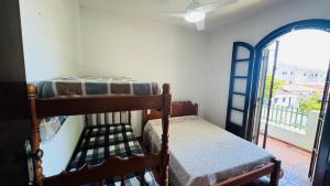 a bedroom with two bunk beds and a window at Casa espaçosa 100m da praia in Ubatuba