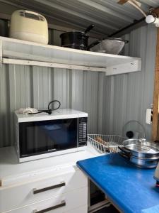 a microwave on a counter in a kitchen at Lilys guest house in Auckland +16 photos
