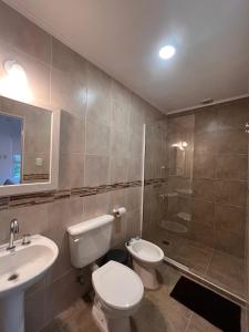 a bathroom with a toilet and a sink and a shower at Costumbres Argentinas Triples En suite in Avellaneda +49 photos