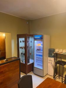 a large refrigerator in a room with a table at Costumbres Argentinas Triples En suite in Avellaneda