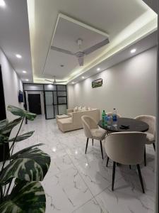 a living room with a couch and a table and chairs at Elite Corners Luxury 2BR Apartment The Gate Mall Faisal Town in Barkat