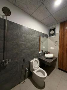 a bathroom with a toilet and a sink at Elite Corners Luxury 2BR Apartment The Gate Mall Faisal Town in Barkat