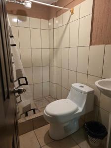a bathroom with a toilet and a sink at Hotel Fontana Real in Quetzaltenango