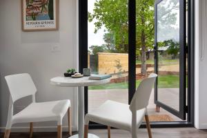 a dining room with a table and chairs and a window at Piccola Verde Tiny House in Hepburn