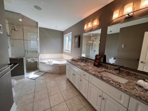 ein Badezimmer mit zwei Waschbecken, einer Badewanne und einer Dusche in der Unterkunft The Bards Roost - 3BR King Ensuite Family Friendly in Stratford + 172 Fotos