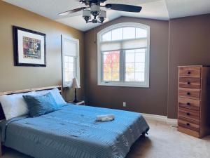 ein Schlafzimmer mit einem blauen Bett und einem Fenster in der Unterkunft The Bards Roost - 3BR King Ensuite Family Friendly in Stratford