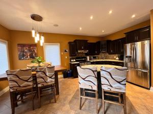 eine Küche mit einem Tisch und einem Edelstahlkühlschrank in der Unterkunft The Bards Roost - 3BR King Ensuite Family Friendly in Stratford