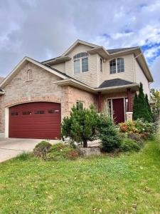 ein großes Haus mit einer roten Garage in der Unterkunft The Bards Roost - 3BR King Ensuite Family Friendly in Stratford