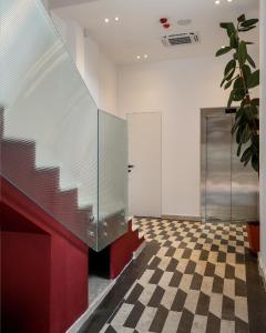 a lobby with a checkered floor and a elevator at BAZAAR HOTEL Center in Tirana