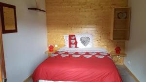 ein Schlafzimmer mit einem roten Bett in einem Zimmer in der Unterkunft Gite du Walsbach in Munster