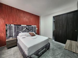 a bedroom with a large bed and a red wall at Apartamentos Batara in Filandia +11 photos