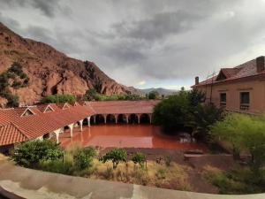 a bridge over a river in front of a mountain at The Baron House in Tupiza +8 photos
