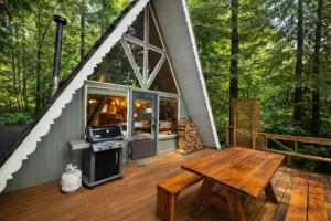 a screened in porch of a house with a picnic table and a stove at Serenity A Frame in Ashford