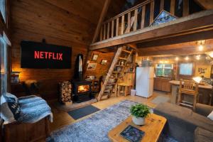 a living room with a staircase in a log cabin at Serenity A Frame in Ashford
