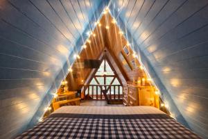 a bedroom with a bed in a room with lights at Serenity A Frame in Ashford