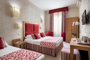 a hotel room with two beds with red accents at Hotel Perseo in Florence
