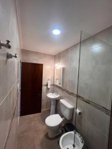a bathroom with a toilet and a sink and a shower at Costumbres Argentinas Dobles En suite in Avellaneda +48 photos