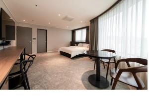 a hotel room with a bed and a table and chairs at Queentown hotel in Goyang