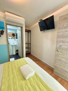 a bedroom with a bed with a television on the wall at Hotel Anauco in Bucaramanga