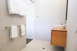a white bathroom with a sink and a shower at Buller Wines in Rutherglen