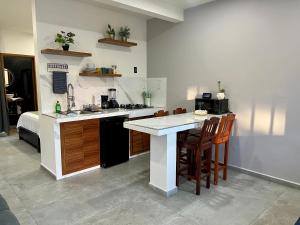 a kitchen with a sink and a counter with chairs at Departamento la estación Tequila in Tequila