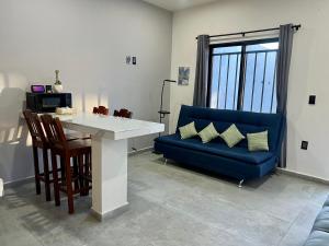 a living room with a table and a blue couch at Departamento la estación Tequila in Tequila +13 photos