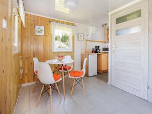 a kitchen with a table and chairs in a room at Comfortable holiday homes, jacuzzi, summer pool in Łacko