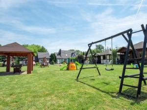 a park with swings and a playground at Comfortable holiday homes, jacuzzi, summer pool in Łacko
