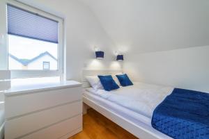 a white bedroom with a bed and a window at Holiday homes with pool, close to the beach in Rewal +24 photos