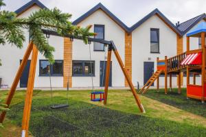 a group of swings in front of a house at Holiday homes with pool, close to the beach in Rewal