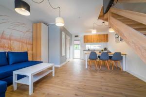 a living room with a blue couch and a kitchen at Holiday homes with pool, close to the beach in Rewal